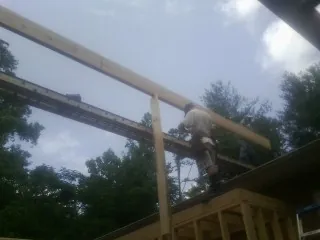 Carpenter setting a ridge beam over a new addition frame — Ice Dam Removal by Roofing Brothers in Grand Junction